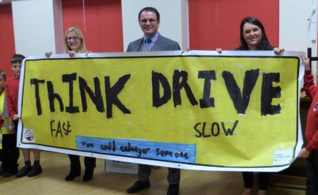 Think fast: drive slow! The message on the winning banner presented to delighted pupils and staff at Coningsbys St Michaels Church of England Primary School.Wilkin Chapman Partner Steve Hennegan was joined at the school by Alison Garfoot (left) from the Road Safety Partnership and Faye Nam from the air ambulance. EMN-180210-161045001