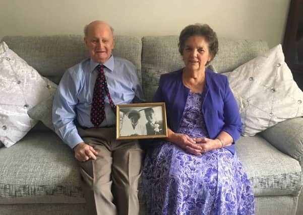 George and Hilda Mason pictured at their home in Horncastle holding their wedding picture from 60 years ago. EMN-180810-105448001