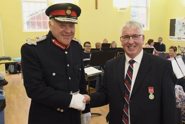 Former Director of Music of Sleaford Concert Band, Jim McQuade receiving BEM from Lord Lieutenant, Toby Dennis. EMN-180810-102940001