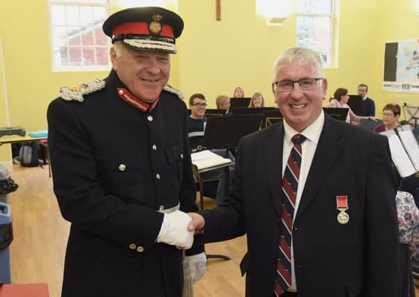 Former Director of Music of Sleaford Concert Band, Jim McQuade receiving BEM from Lord Lieutenant, Toby Dennis. EMN-180810-102940001