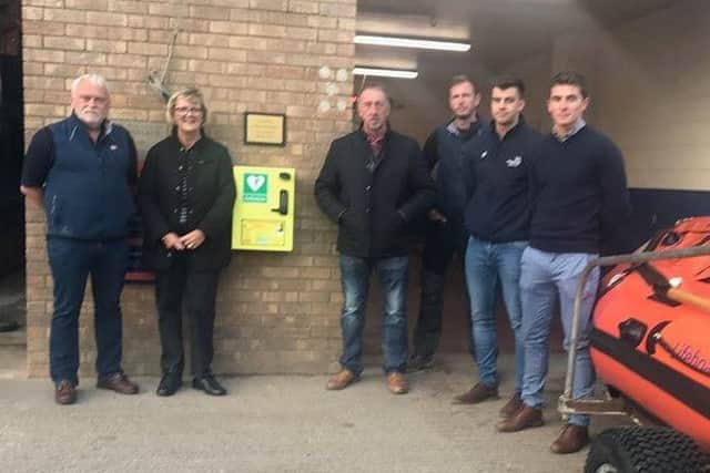 Kay and Paul Rawlinson with RNLI voluntee4rs at the handover of the defibrillator at the Lifeboat Station. ANL-180910-075147001