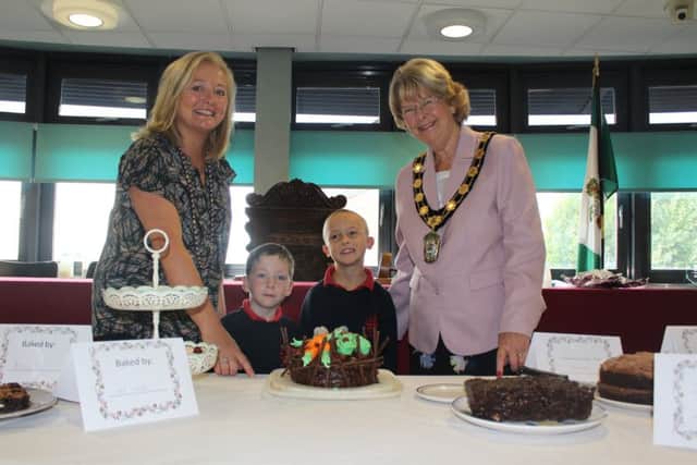 Eve Fawcett-Moralee and Councillor Pat Mewis with Keegan Holland and Jack Newbury standing with the winning cake entry (centre). EMN-180910-095750001