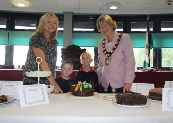 Eve Fawcett-Moralee and Councillor Pat Mewis with Keegan Holland and Jack Newbury standing with the winning cake entry (centre). EMN-180910-095750001