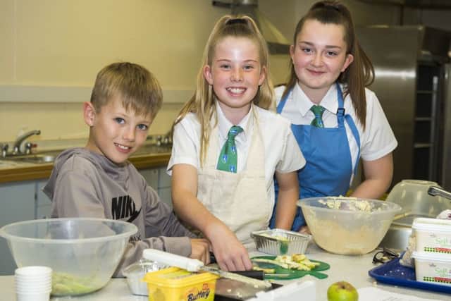 Pictured is Louth Academy Year 8 students, Lucy Pearson and Evie Wood making apple crumble with a little help from 10-year-old Academy visitor Henry Househam from Legbourne.