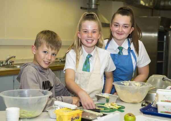 Pictured is Louth Academy Year 8 students, Lucy Pearson and Evie Wood making apple crumble with a little help from 10-year-old Academy visitor Henry Househam from Legbourne.