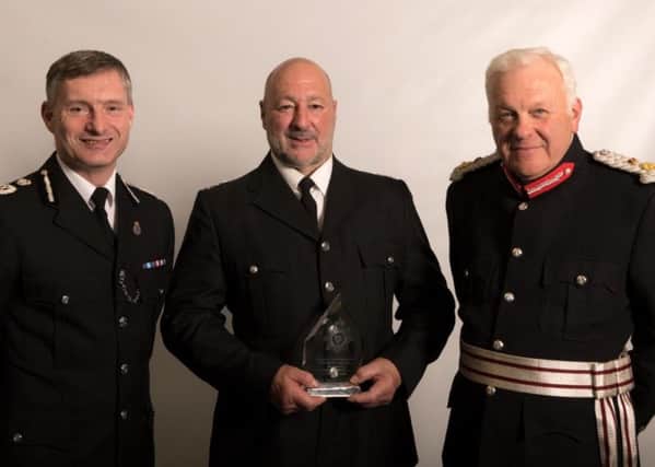 Special Constable Nick Lamb receives his officer of teh year award from Chief Constable Bill Skelly and Lord Lieutenant of Lincolnshire Toby Dennis. EMN-181110-171057001