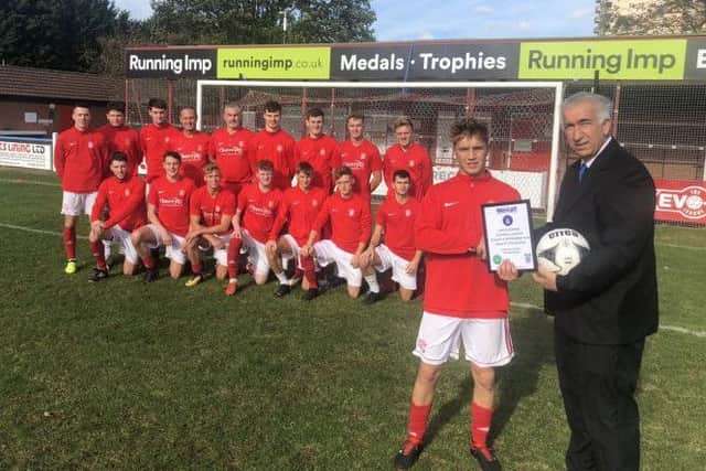 Lincoln United Development squad captain Joe Silson is seen receiving the August and September Team of the Month Award from League Development Officer Ian Hughes.