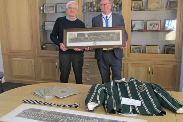 Mal Jones, left,from the Rase Heritage Society, and a former teacher at De Aston, presents the items to head teacher Simon Porter EMN-181016-154519001