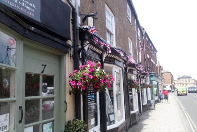Hanging baskets and bunting on business premises in North Street
