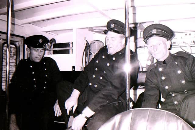 The Sleaford firefighters getting into their protective gear in the back of the fire engine. EMN-181029-145631001