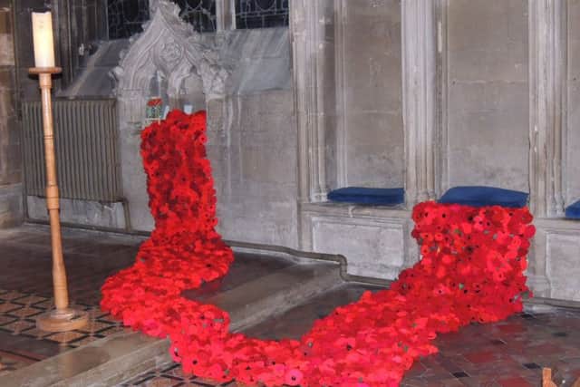 Poppies pour out of recesses around the altar of Heckington Church in the Sea of Poppies display. EMN-181030-100716001