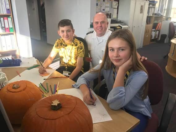 Mackenzie Weir, 11, and Lilley-May Pidgley, 10, busy working on new posters for Halloween and Bonfire Night with Lee  Marsh, Community Fire Safety Officer.