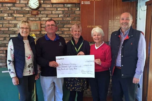 Janet Read and Lee Francis hand over the cheque to Daphne and Nigel Simpson.