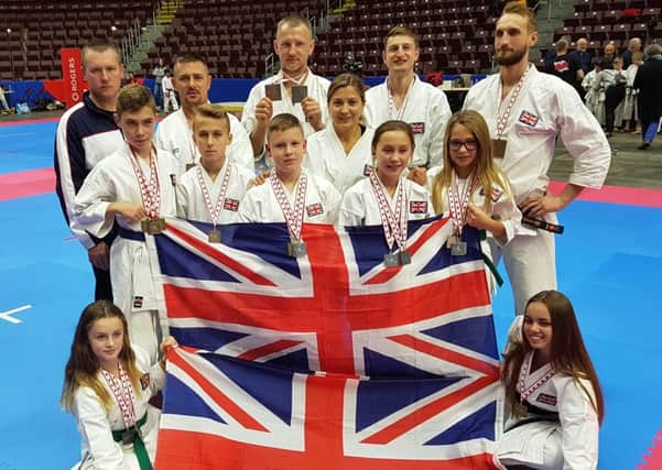 The TKAB medallists representing Great Britain celebrate with their coach Zbigniew Godszisz in Canada.