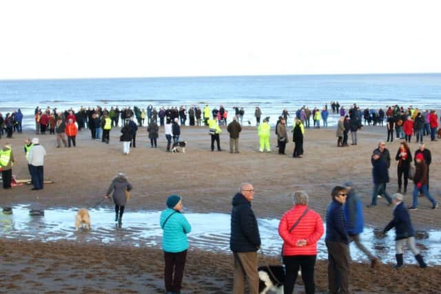 Thousands of people packed Sutton on Sea beach throughout the day to see the sand portrait take shape. Photo: Chloe West.