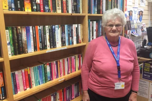 Volunteer Jean at St Barnabas Hospice bookshop in Louth prior to the flooding.