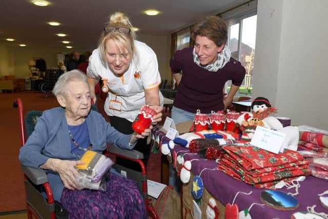 Christmas Fair at Mayfields Care Home. 102-year-old resident Hannah Bailey with Sylvia Markham (carer) looking at Angela Horton's christmas crafts, who was raising money for Boston & Hakusan exchange programme. EMN-181120-163103001