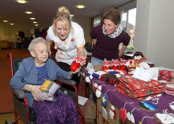 Christmas Fair at Mayfields Care Home. 102-year-old resident Hannah Bailey with Sylvia Markham (carer) looking at Angela Horton's christmas crafts, who was raising money for Boston & Hakusan exchange programme. EMN-181120-163103001