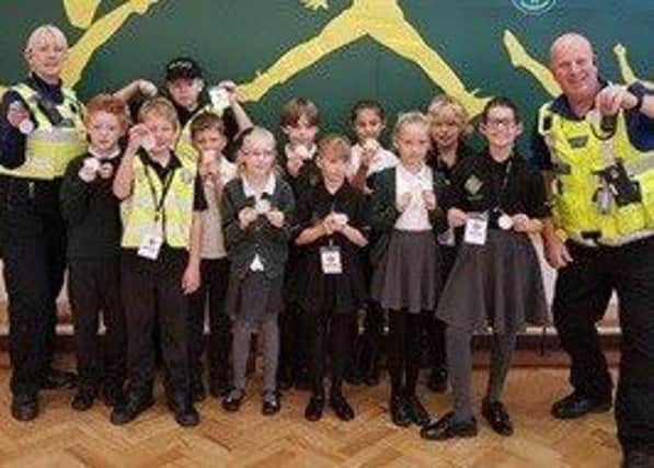 PCSO's and children holding the reflective badges. EMN-180312-151254001