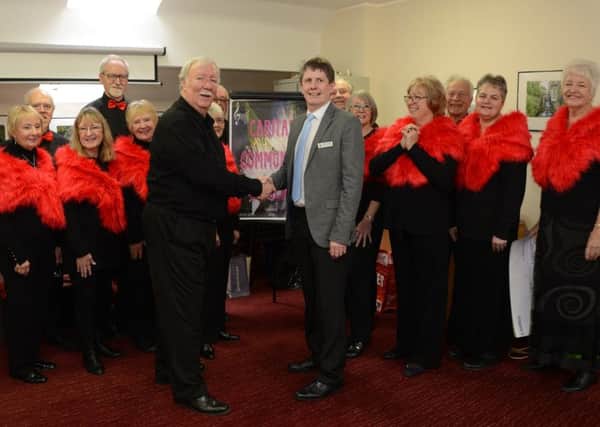 Caritas Community Singers and their director, David Roy-Martin, pictured shaking hands with Kevin Rudge from The Royal Star & Garter Homes.