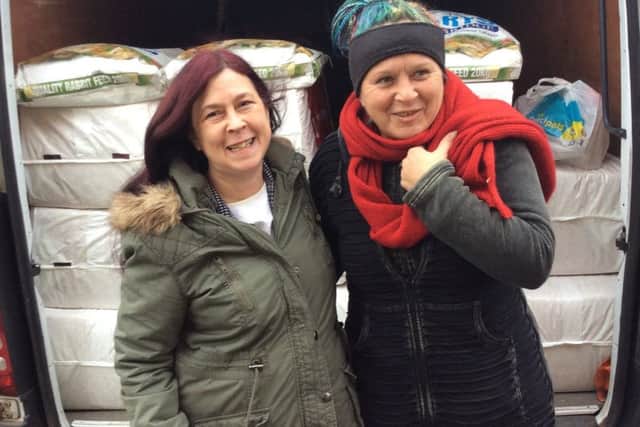 Kay Chadwick receives her donation of animal feed and provisions from Cat Darby for her rabbit and guinea pig sanctuary. EMN-181231-094010001