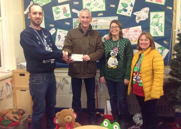 Headteacher Steve Bladon (left) pictured receiving a cheque from The Lions.