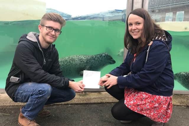 Samantha Phillips, ELDCs Economic Development Officer, presents a sticker to Matt Yeadon of Natureland Seal Sanctuary in Skegness to launch the authority's new Dog Friendly campaign. ANL-190301-173719001