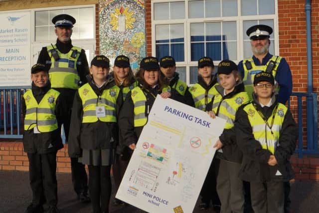 PCSOs Neal Wallace and Neil Harrison with some of Market Rasens mini police and the poster they designed. EMN-190115-071412001