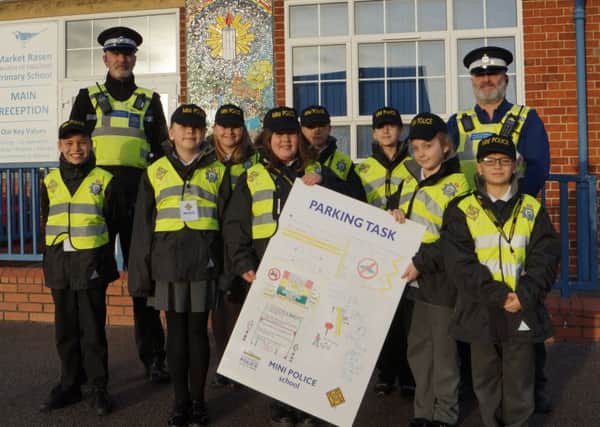 PCSOs Neal Wallace and Neil Harrison with some of Market Rasens mini police and the poster they designed. EMN-190115-071412001