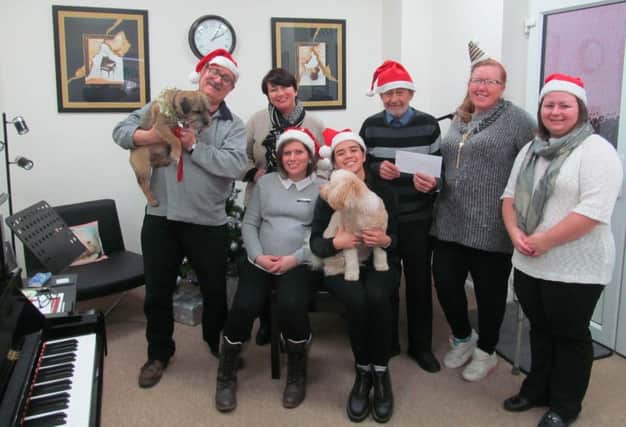 Pictured at the cheque presentation (from left) are Martin the dog, Grahame Baumber (tutor), April Chapman (tutor), Rachel Butler (tutor), Lulu Grainger (tutor) with Martha the dog, Keith of Keiths Rescue Dogs, Pam Ormrod (Just Sing Choir) and Hayley Brown. ANL-190901-145237001