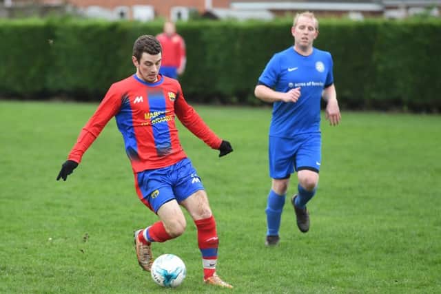 Fosdyke (blue) v Northgate Olympic (red). Nath Thompson with the ball for Northgate Olympic