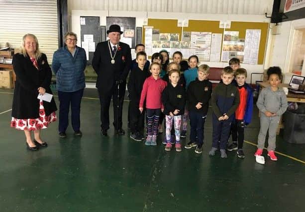 BADAC representatives are pictured handing £250 over to the Royal British Legion, the money raised from November's Poppy Run. Also pictured are some of the club's Friday night juniors.