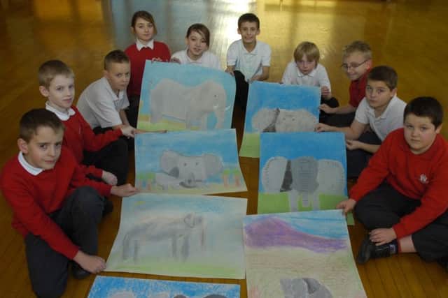 Year Six, Five, and Four children with their artwork.