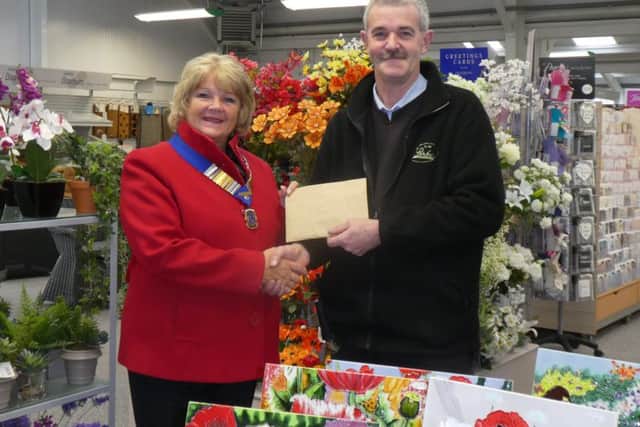 Tim McLeod-Rice of Anwick Garden Centre presenting the £750 cheque to Sleaford Lions President Sue La Roche. EMN-190129-152325001