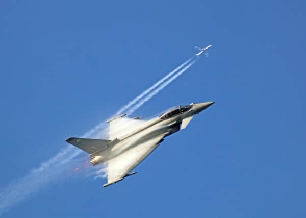 Perfect timing as the Typhoon climbs and crosses the vapour trail of a passing jet. EMN-190218-124038001
