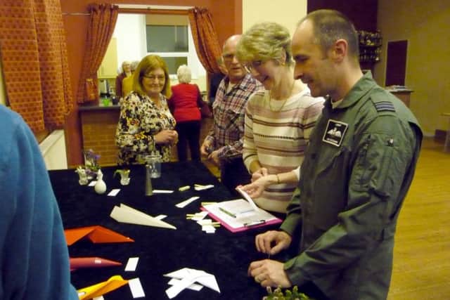 Squadron Leader Mark 'Disco' Discombe AFC RAF OCBBMF inspecting the paper planes in the competition EMN-190213-175111001