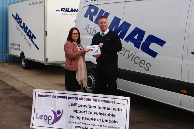 Heidi Walton receives a donation from Rilmac Asbestos Director, Ryan Hubbard.
