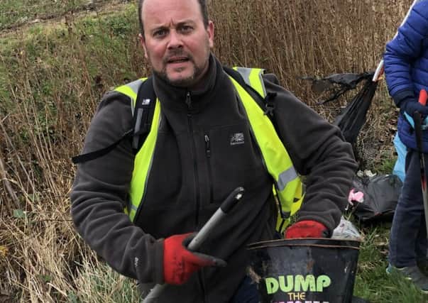 Mark Douglas collecting flytipped rubbish. EMN-190226-120536001