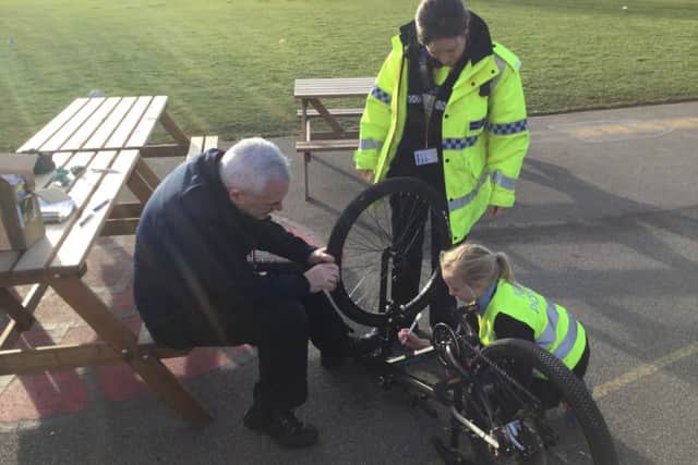PCSOs Colin Ironmonger and Nic Woolerton work on the bicycles with Minipolice officer Olivia. EMN-190225-175448001