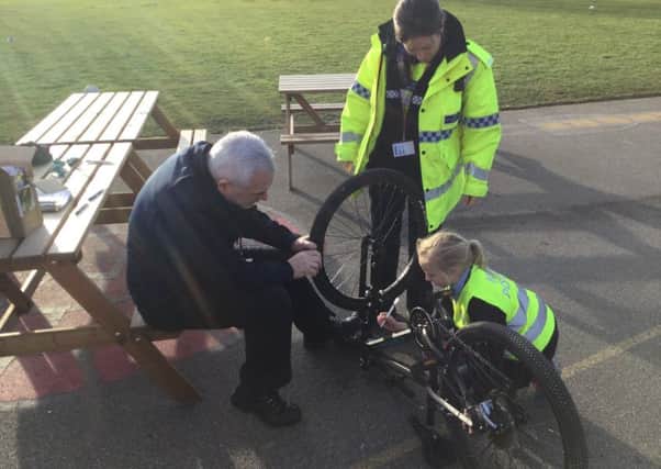 PCSOs Colin Ironmonger and Nic Woolerton work on the bicycles with Minipolice officer Olivia. EMN-190225-175448001