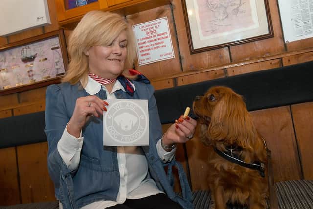 Luca of Dog Friendly Lincolnshire gets a treat after presenting Admiral Benbow owner Sarah Jane South with an East Lindsey District Council 'We Are Dog Friendly' sticker.