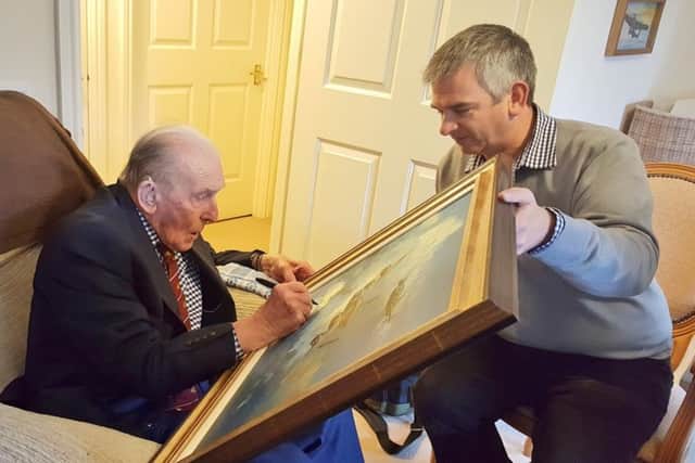 George Johnny Johnson signing the star lot in the auction