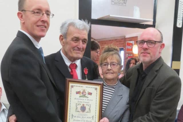 John Monk MBE and his wife Maureen, alongside sons Andrew (left) and David (right), holding the Freedom of the Parish scroll.