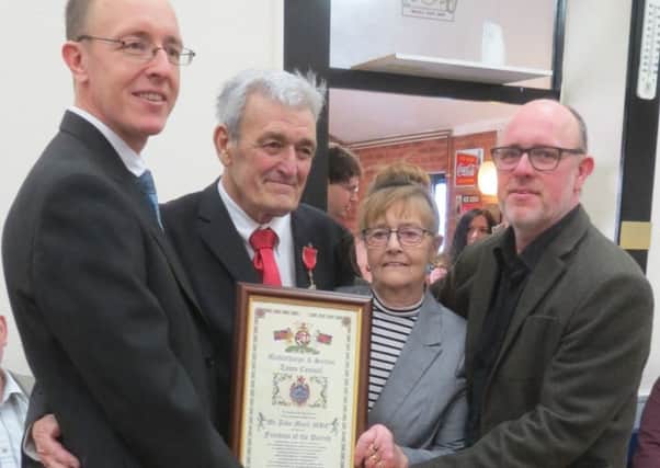John Monk MBE and his wife Maureen, alongside sons Andrew (left) and David (right), holding the Freedom of the Parish scroll.