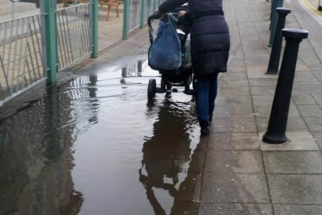 Negotiating the giant puddle on the pavement on Southgate in Sleaford. EMN-190325-183442001