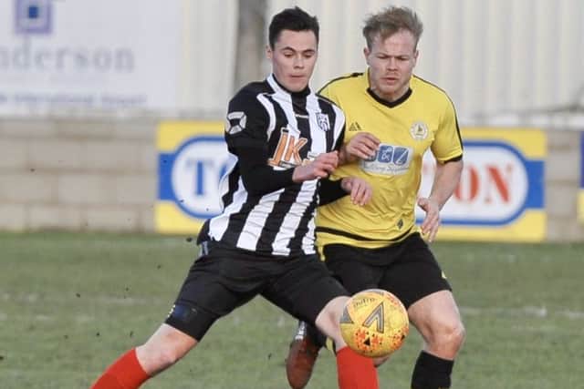 Reece Moody (stripes) who scored a hat-trick for Brigg Town CIC in their cup victory against Louth EMN-190325-095502002