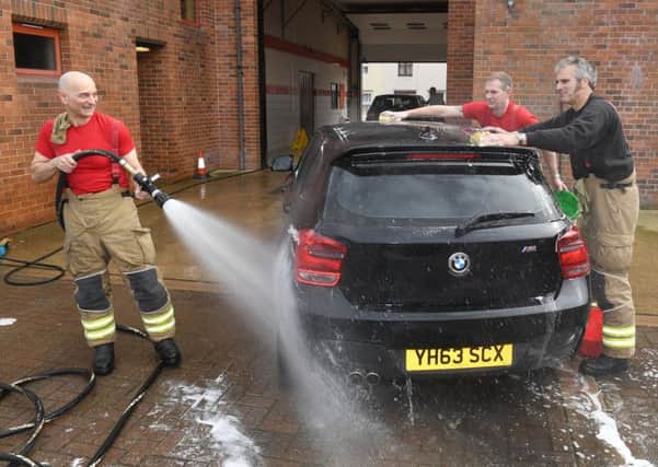 Billingborough fire station charity car wash. L-R Firefighter Mario Dimaro, Firefighter Peter Vince, Watch Manager Gary Bellamy. EMN-190325-102913001