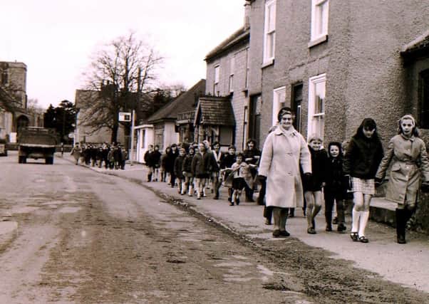 Children and staff troop along Ruskington High Street between their two school sites. EMN-190804-232034001