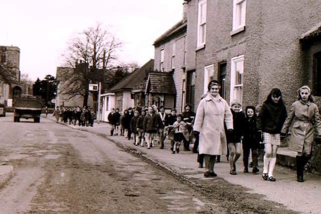 Children and staff troop along Ruskington High Street between their two school sites. EMN-190804-232034001