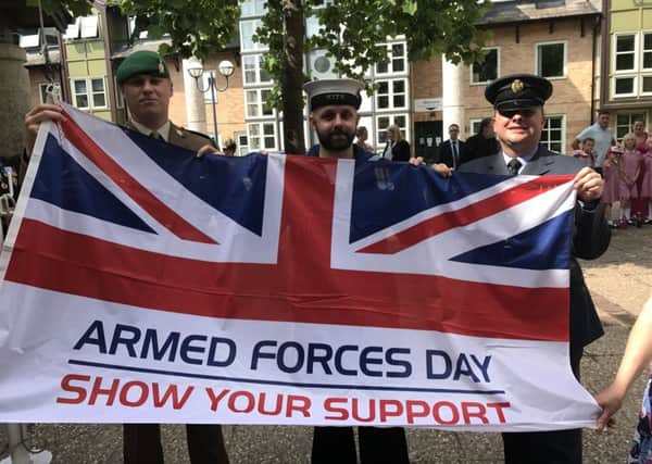 Forces personnel with the Armed Forces Day flag in Sleaford. EMN-190419-113240001